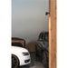 Black metal wall-mounted spotlight illuminating a garage with white, brown, and black cars.