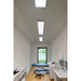 Recessed white LED panel lights in a perforated ceiling in a medical exam room.
