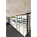 Acoustic ceiling tiles, recessed lighting, and glass wall in an office space.