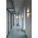 Hallway with white walls, blue floor, metal ductwork, glass-paneled doors, and white wall-mounted sconces.