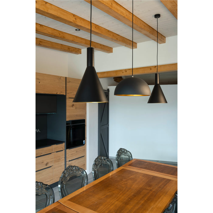 Three black metal pendant lights hanging above a wood dining table in a modern kitchen with exposed beams.
