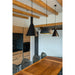 Three black metal pendant lights hanging above a wood dining table in a modern kitchen with exposed beams.