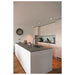 Modern kitchen with white cabinets, gray countertop, stainless steel sink, and wood floor.