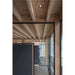 Modern office interior with exposed wood beams, black framed glass walls, and gray acoustic panels.