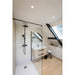 Modern bathroom with black shower fixture, light wood vanity, and glass shower screen.