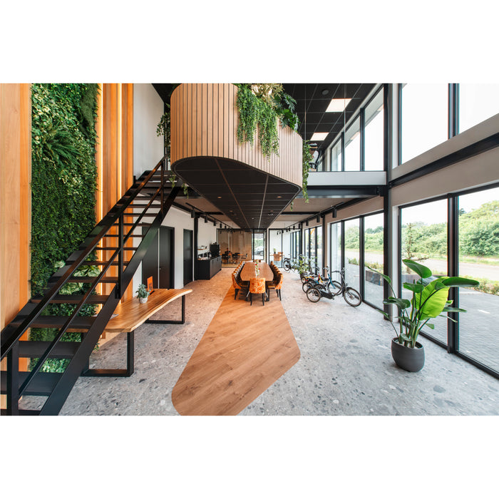 Modern office interior with black steel stairs, wood accents, living wall, and polished concrete floors.