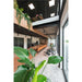 Modern office interior with wood paneling, black accents, large windows, plants, and a long conference table.