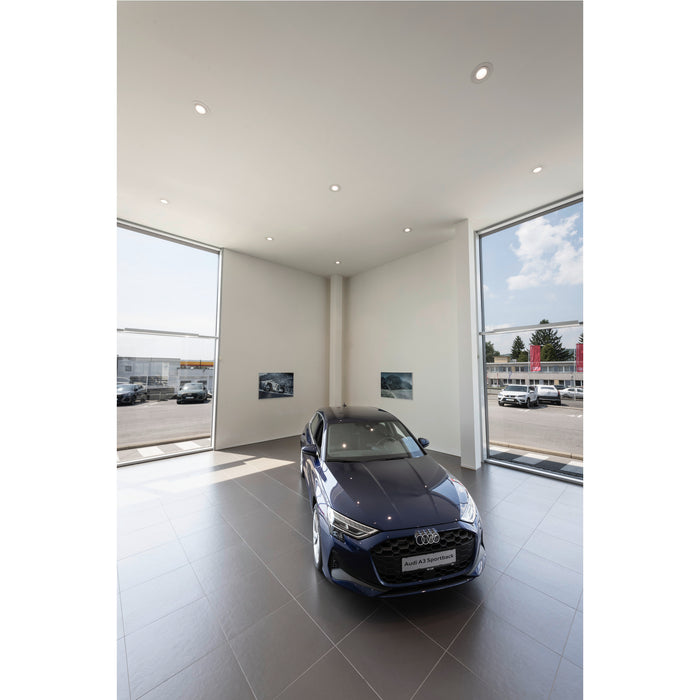 Blue Audi A3 Sportback car in a showroom with large windows.