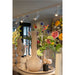 Ceramic vases in beige and white with glossy finish, displayed with colorful flowers and track lighting.