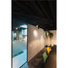 Office interior with black ceiling, track lighting, frosted glass door, and green/yellow upholstered chairs.