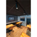 Restaurant interior with wood tables, leather chairs, track lighting, and a stone accent wall.