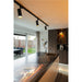 Black track lighting with cylindrical spotlights, ceiling mounted.