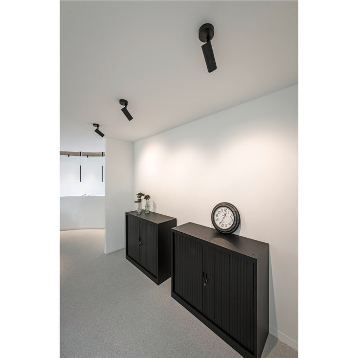 Interior with black metal cabinets, wall clock, and ceiling-mounted black track lighting.