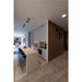 Modern kitchen with white cabinets, light countertop, black bar stools, and wood slat wall.