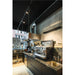 Modern kitchen with black marble countertops, stainless steel appliances, and a Nespresso machine.