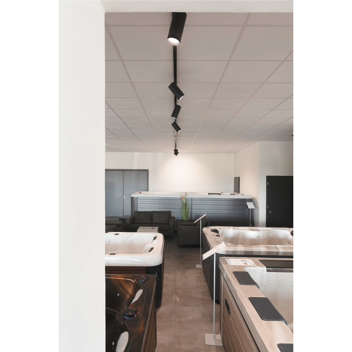 Showroom with various hot tubs and black track lighting mounted on the ceiling.