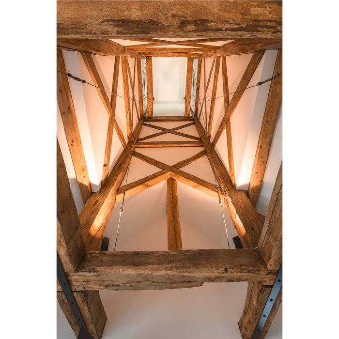 Exposed wood beam ceiling with skylight, natural finish, and metal support brackets.