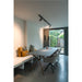 Modern dining room with gray tabletop table, wood legs, gray fabric chairs, and track lighting.