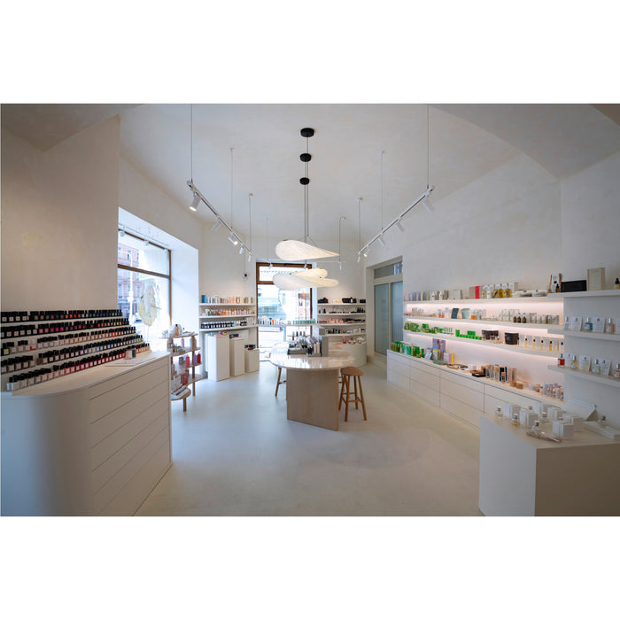 Retail space interior with white walls, light wood furniture, and product displays.