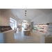 Retail space interior with white walls, light wood furniture, and product displays.