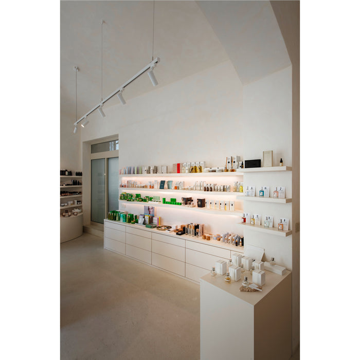 Interior view of a retail store with white shelving and cabinets displaying various beauty and skincare products.