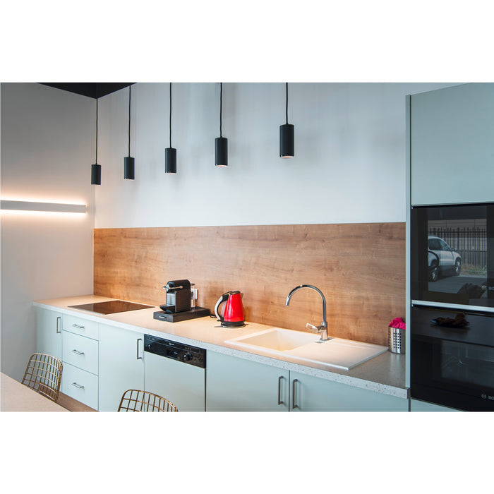 Modern kitchen with light blue cabinets, wood backsplash, stainless steel faucet, and black pendant lights.
