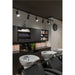 Salon interior with white ceramic shampoo bowls, black cabinets, track lighting, and black leather chairs.