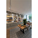 Retail store interior with gray built-in shelving, wood table with colorful ceramic plates, and patterned floor tiles.