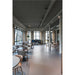 Modern office cafeteria with wood chairs, gray upholstered seating, and large windows.