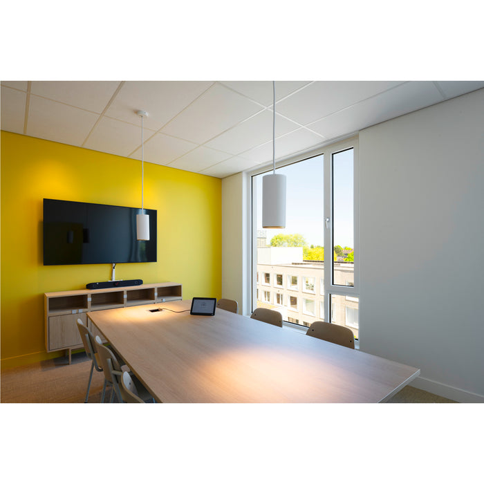 Conference room with light wood table, beige chairs, yellow wall, and white cylindrical pendant lights.