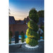 Green spiral topiary tree in a gravel and white stone garden with black stone pillars.