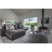 Modern living room with black leather sectional sofa, gray rug, and suspended black fireplace.