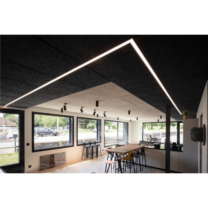 Acoustic ceiling panels, black and beige, with recessed linear lighting in a modern office space.