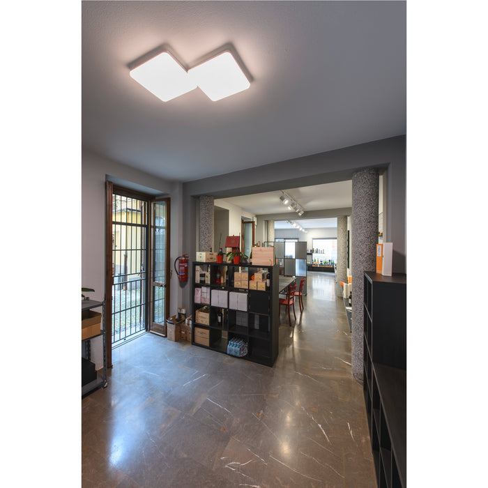 Modern office interior with gray walls, marble floor, black shelving, and a square white LED ceiling light.