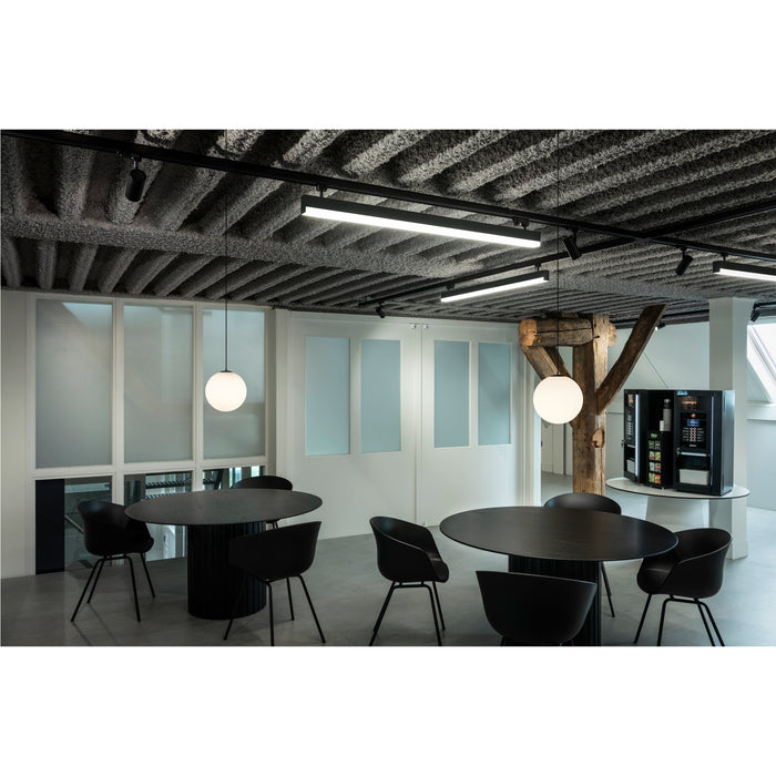 Modern office space with black wood tables, black chairs, globe pendant lights, and track lighting.