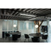 Modern office space with black wood tables, black chairs, globe pendant lights, and track lighting.