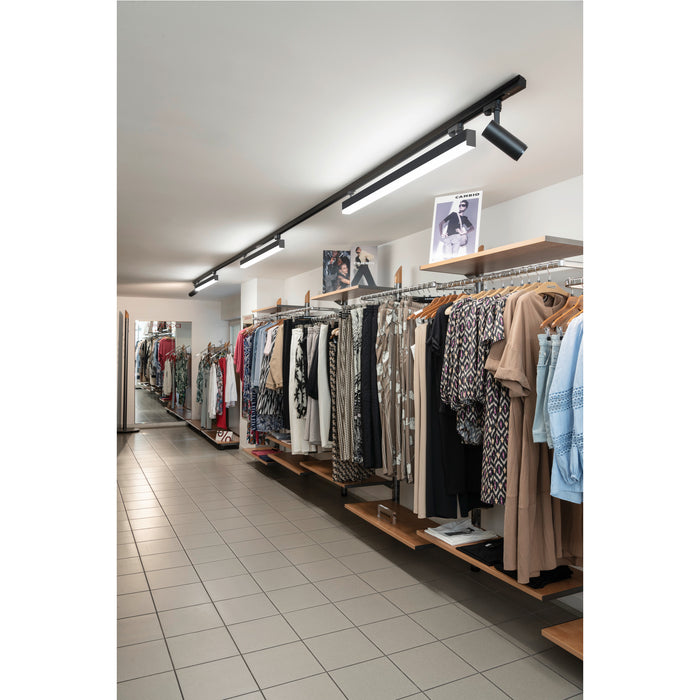 Retail store interior with clothing racks, wood shelves, and black track lighting mounted on the ceiling.