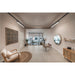 Salon interior with beige walls, tile floor, wood furniture, jute rug, and black track lighting.