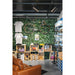 Bike shop interior with steel frame bicycle mounted on a green wall, wooden display crates, and a brown leather sofa.