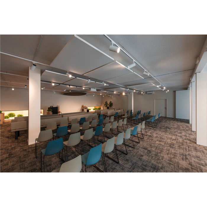 Conference room with blue and beige chairs, gray carpet, and track lighting.