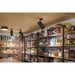 Interior view of a liquor store with shelves stocked with bottles and black, ceiling-mounted track lighting.