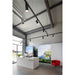 Black track lighting system with cylindrical fixtures, suspended from the ceiling.