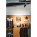 Black track lighting fixture, mounted on ceiling, illuminating Animoz apparel display.