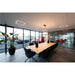 Conference room with light wood table, black velvet chairs, and linear LED ceiling lights.