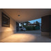 Modern gray cube ceiling light illuminating a covered driveway.