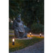 Gray gorilla statue in a park setting with black cylindrical outdoor lights.