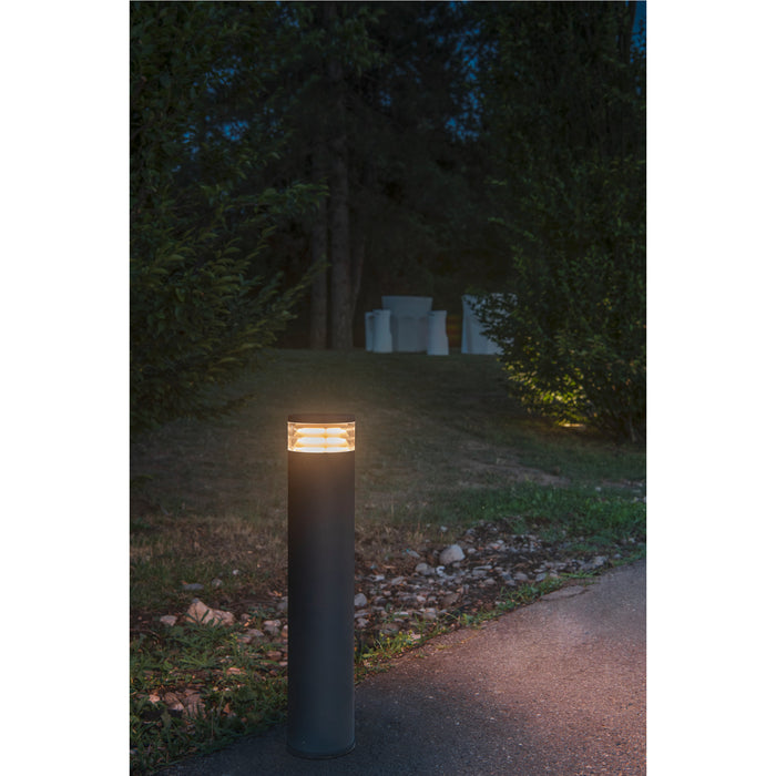 Dark gray bollard light fixture, ground mounted.