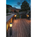 Black bollard light fixture on wood deck, outdoor landscape lighting.