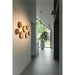 Wall-mounted wood slice art with colorful painted designs, in a modern hallway.