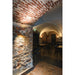 Interior of restaurant with brick walls and arched ceiling, featuring a white wall-mounted spotlight.